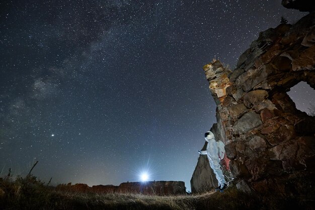 El hombre en traje espacial camina en un área abandonada