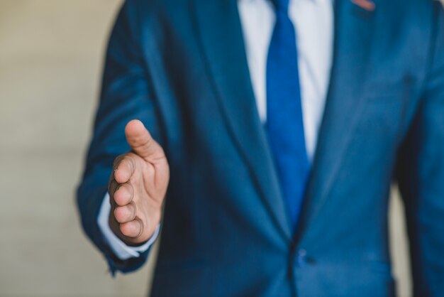 Hombre con traje extendiendo la mano