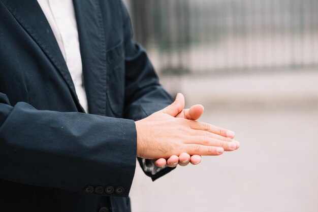 Hombre en traje de frotarse las manos