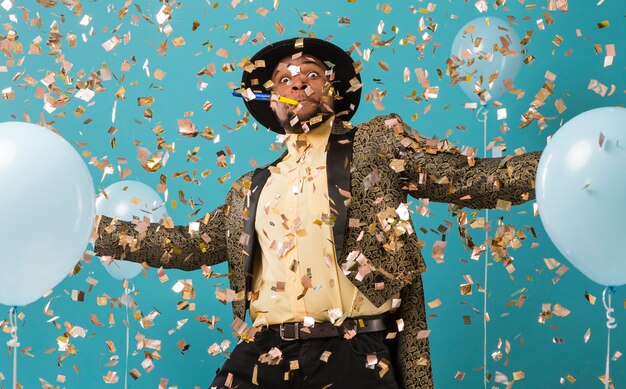 Hombre en traje y gafas de sol en fiesta con globos