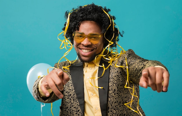 Hombre de traje y gafas de sol en la fiesta con retrato de globos