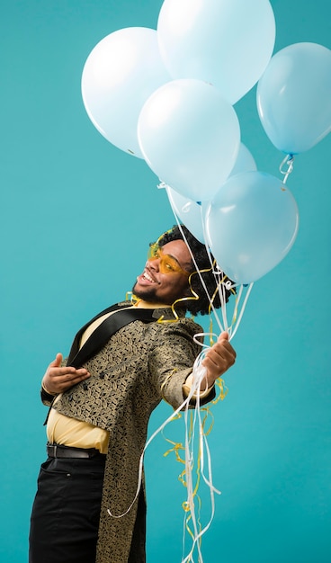 Foto gratuita hombre de traje y gafas de sol en la fiesta con retrato de globos