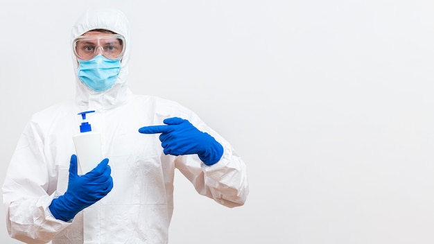 Foto gratuita hombre en traje de materiales peligrosos con botella de jabón