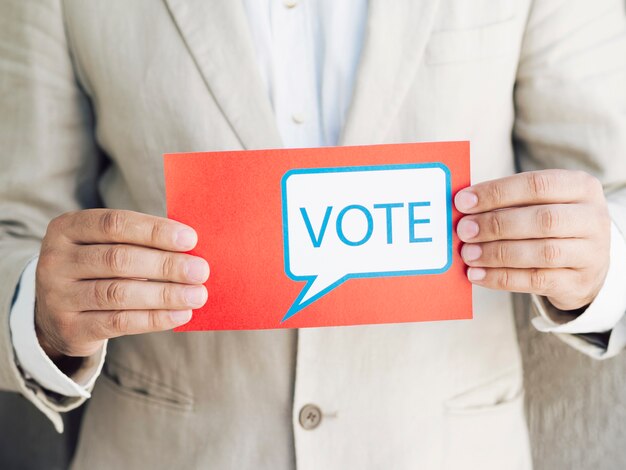 Hombre de traje con un mensaje de votación