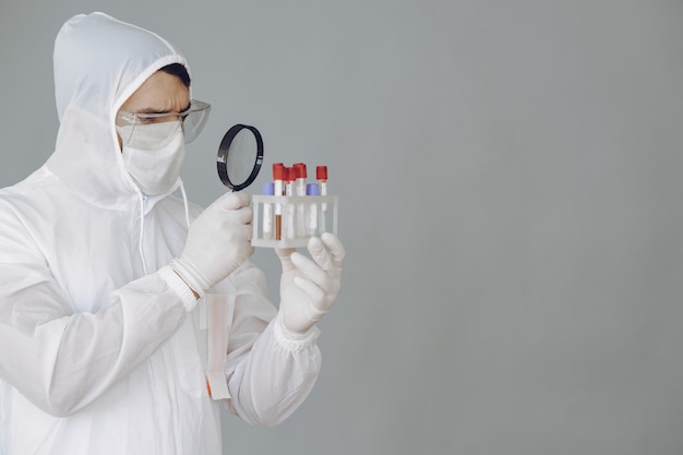 Hombre con traje protector y gafas trabajando en laboratorio