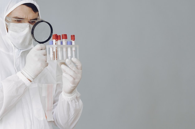 Hombre con traje protector y gafas trabajando en laboratorio