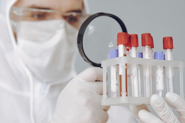 Hombre con traje protector y gafas trabajando en laboratorio