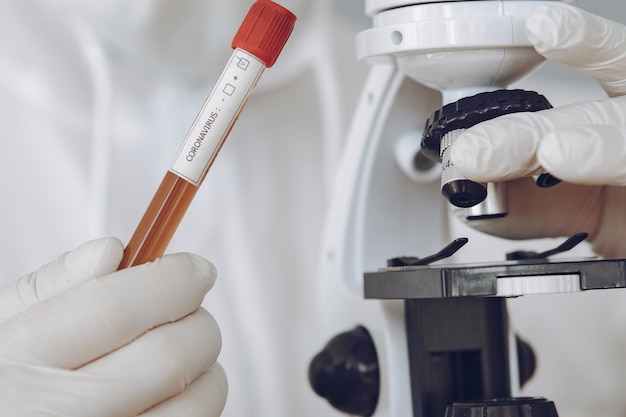 Foto gratuita hombre con traje protector y gafas trabajando en laboratorio