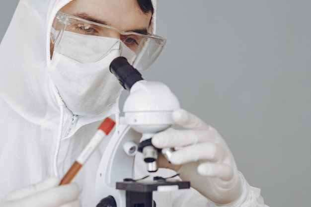 Foto gratuita hombre con traje protector y gafas trabajando en laboratorio