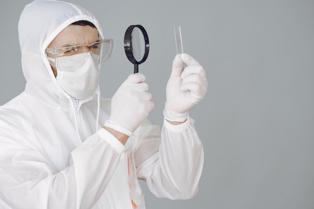 Hombre con traje protector y gafas trabajando en laboratorio