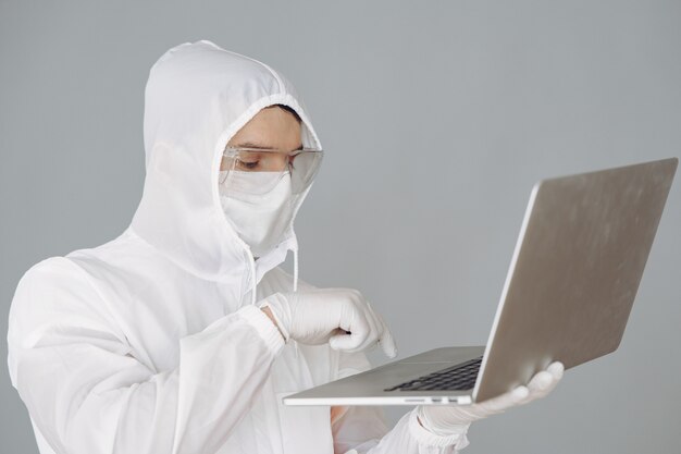 Hombre con traje protector y gafas trabajando en laboratorio