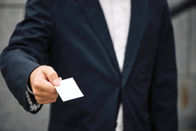 Foto gratuita hombre con traje que ofrece la tarjeta de visita