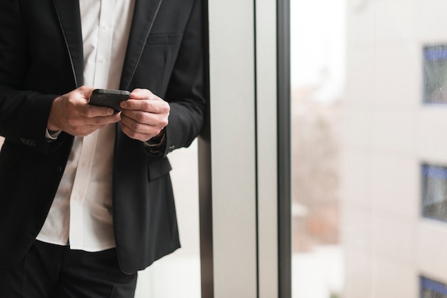 Foto gratuita hombre en traje con teléfono inteligente