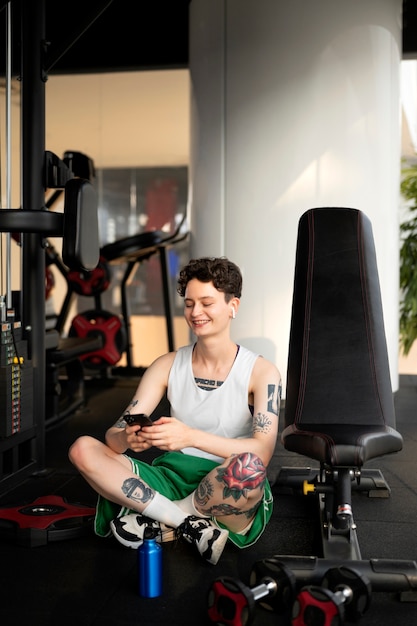 Foto gratuita hombre trans haciendo ejercicio en el gimnasio