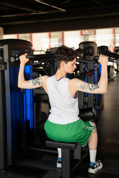 Hombre trans trabajando y haciendo ejercicio en el gimnasio