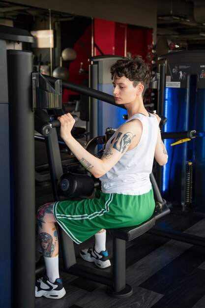 Hombre trans trabajando y haciendo ejercicio en el gimnasio