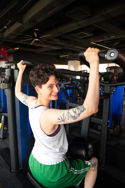 Hombre trans trabajando y haciendo ejercicio en el gimnasio