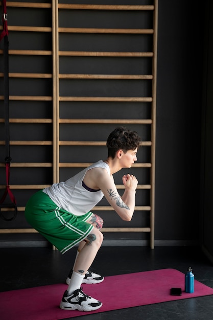 Foto gratuita hombre trans trabajando y haciendo ejercicio en el gimnasio