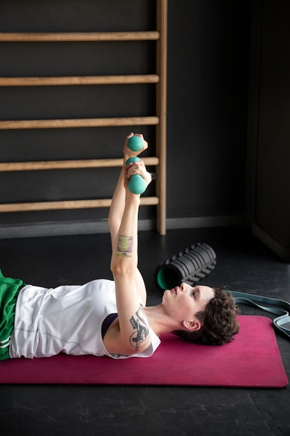 Foto gratuita hombre trans trabajando y haciendo ejercicio en el gimnasio