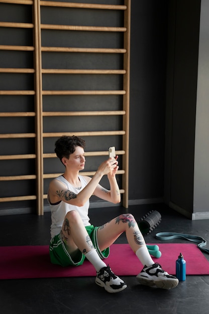 Foto gratuita hombre trans trabajando y haciendo ejercicio en el gimnasio