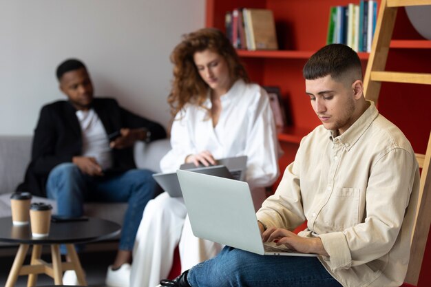 Foto gratuita hombre trans en el trabajo con laptop