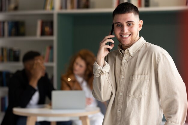 Hombre trans en el trabajo usando su teléfono inteligente