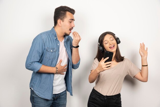 Foto gratuita hombre tratando de hablar con la mujer que está escuchando música.