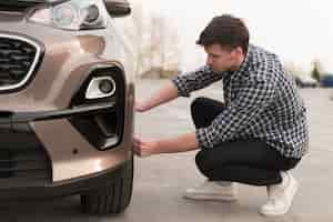 Foto gratuita hombre tratando de reemplazar la rueda del coche