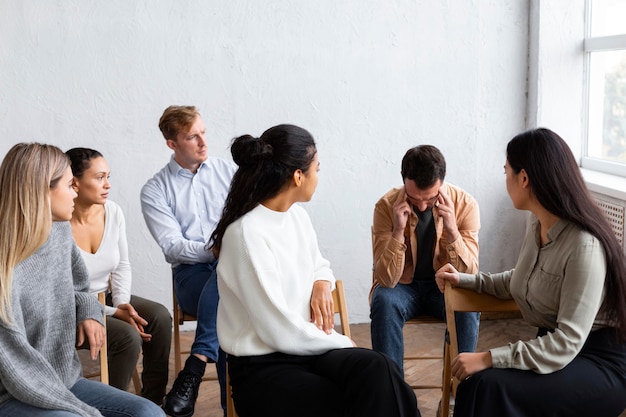 Hombre triste hablando de sus problemas en una sesión de terapia de grupo