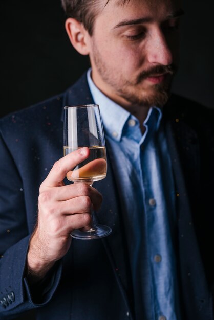 Hombre triste en pie azul con copa de champán en la mano