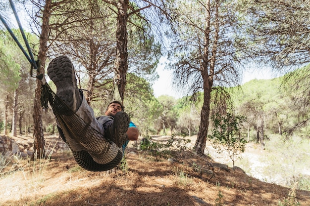 Hombre tumbado en hamaca en bosque