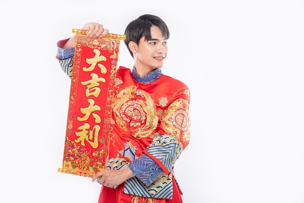El hombre usa traje Cheongsam y le da a la familia la tarjeta de felicitación china para la suerte en el año nuevo chino