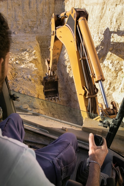 Hombre usando una excavadora para cavar a la luz del día