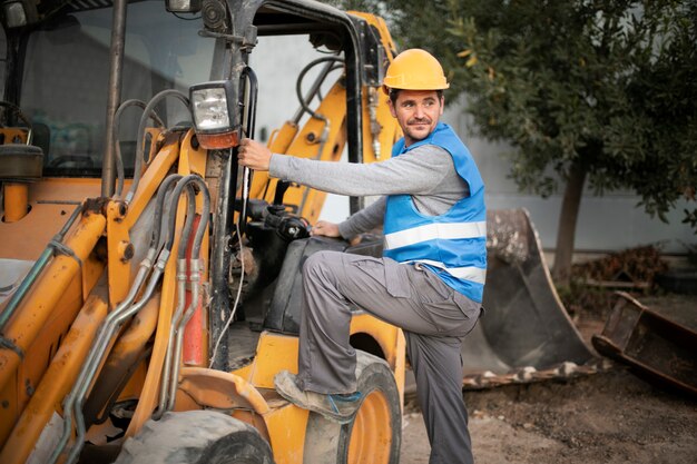 Hombre usando una excavadora para cavar a la luz del día