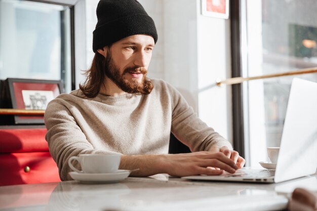 Hombre usando laptop en café