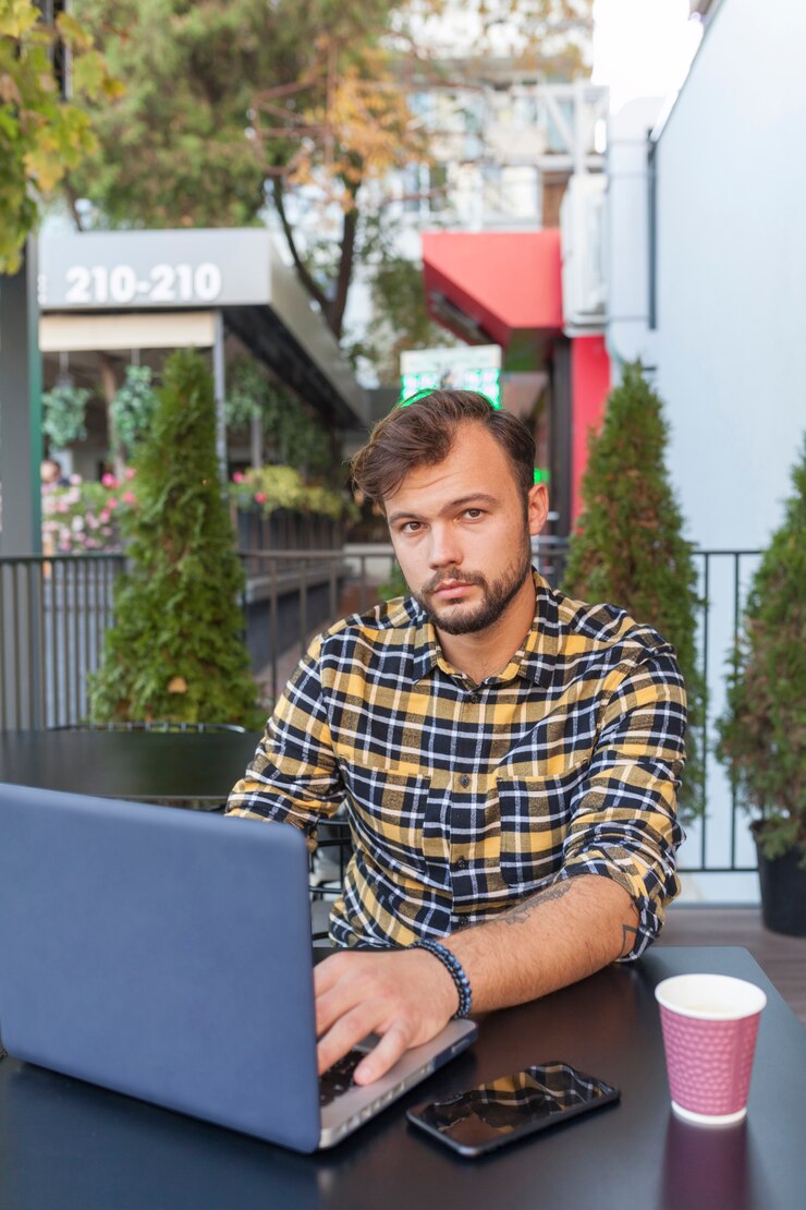 Foto gratuito hombre usando laptop en cafetería