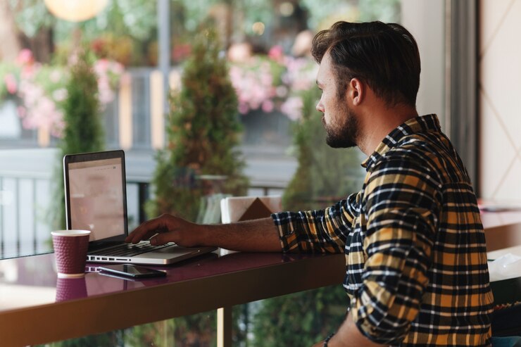 Foto gratuito hombre usando laptop en cafetería