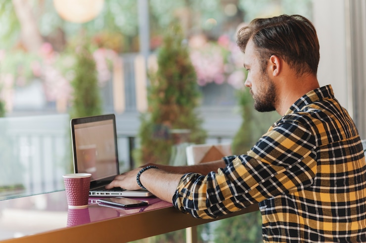 Foto gratuito hombre usando laptop en cafetería