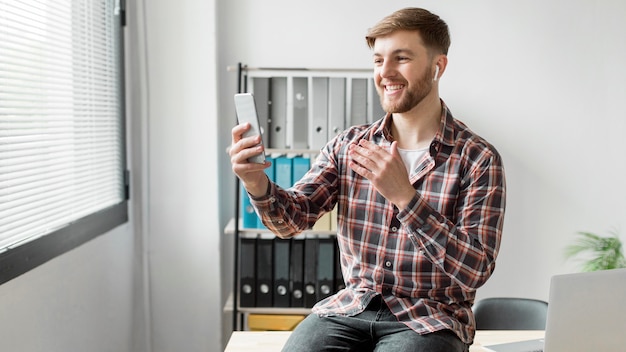 Hombre usando móvil para videollamada