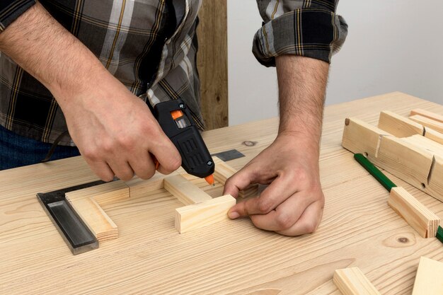 Hombre usando pegamento en concepto de taller de carpintería de madera