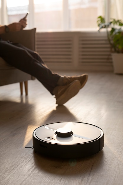 Foto gratuita hombre usando un robot aspirador en la sala de estar