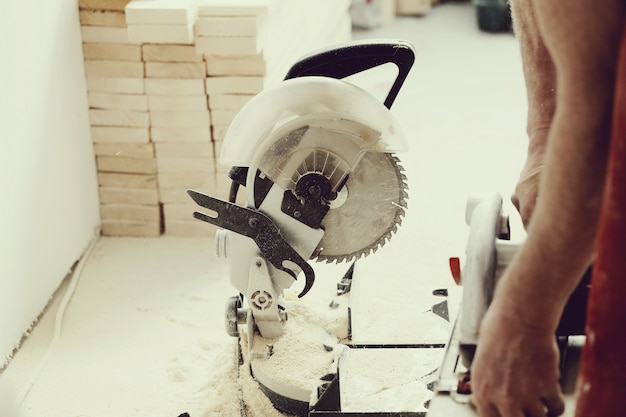 Foto gratuita hombre usando sierra eléctrica en taller de carpintería