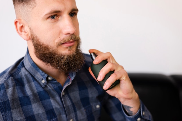 Hombre usando un spray después de cortarse el pelo