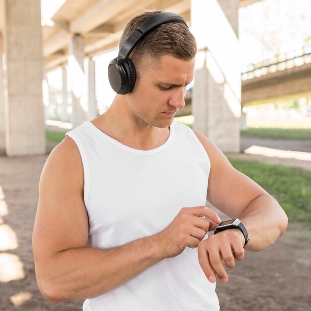 Hombre usando su reloj inteligente antes de entrenar