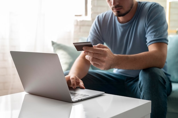 Hombre usando su tarjeta de crédito para jugar en línea para un pedido
