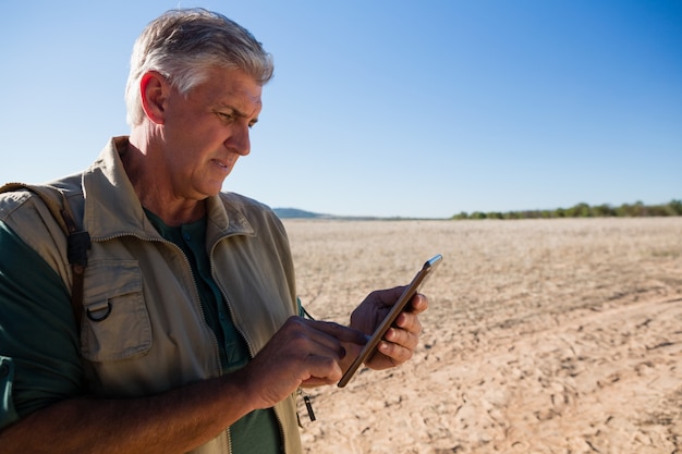 Hombre usando tableta digital en paisaje