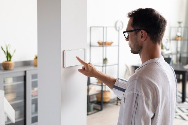 Hombre usando una tableta en su casa inteligente