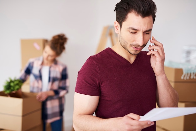 Hombre usando teléfono celular en su nuevo hogar