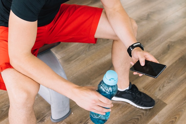 Foto gratuita hombre usando el teléfono después de entrenar