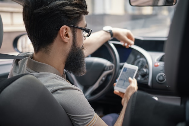 Hombre usando el teléfono móvil mientras se conduce.